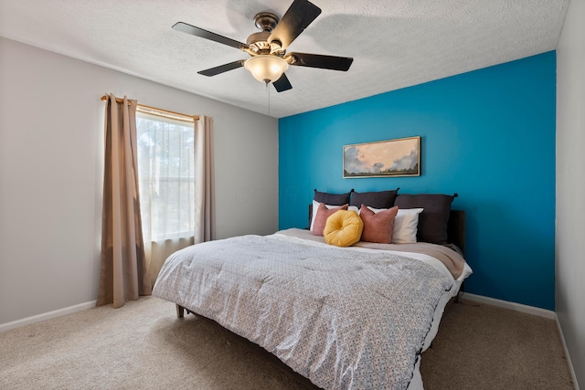 bedroom with ceiling fan, carpet floors, and a textured ceiling