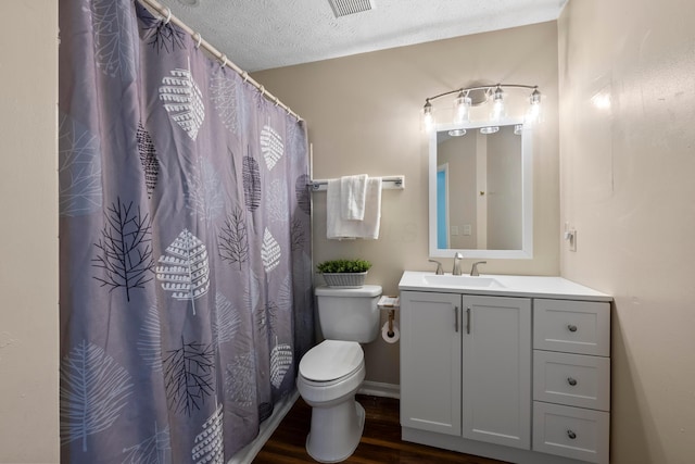 bathroom with vanity, hardwood / wood-style flooring, toilet, and a textured ceiling