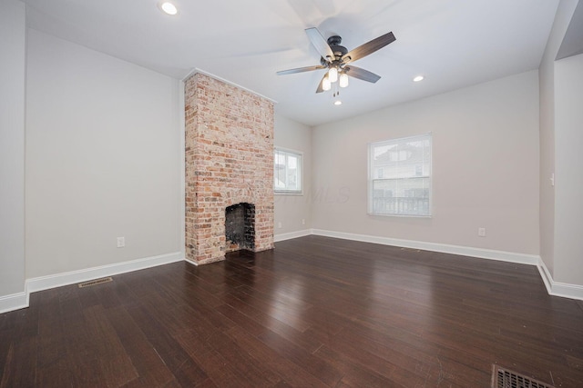 unfurnished living room with ceiling fan, a brick fireplace, and dark hardwood / wood-style flooring