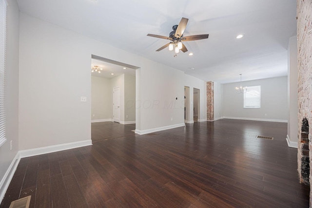 unfurnished living room with dark hardwood / wood-style floors and ceiling fan with notable chandelier