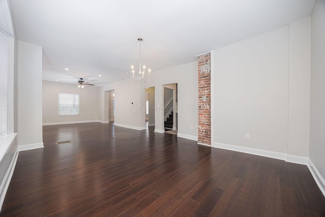 spare room featuring dark hardwood / wood-style flooring and ceiling fan with notable chandelier