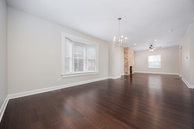 unfurnished living room with a brick fireplace, ceiling fan with notable chandelier, and dark hardwood / wood-style flooring