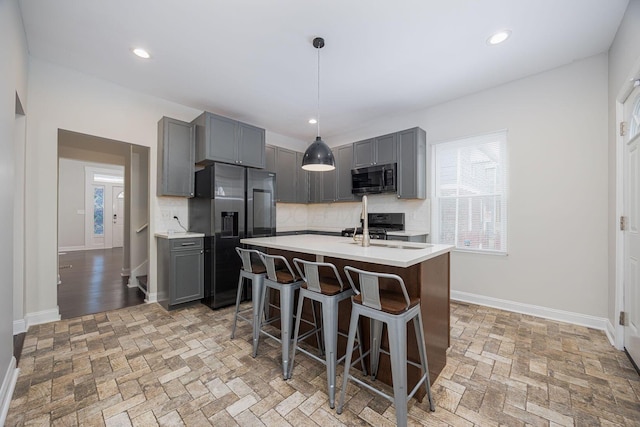 kitchen with backsplash, appliances with stainless steel finishes, and gray cabinetry