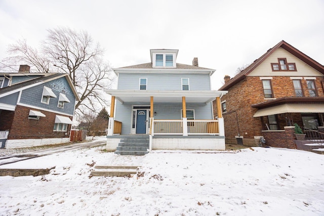 snow covered house featuring covered porch