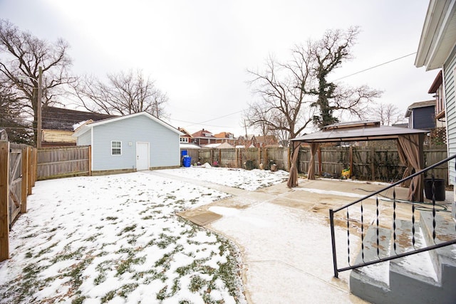 yard layered in snow featuring a gazebo and an outdoor structure