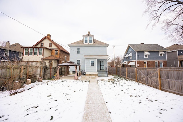 snow covered house featuring a gazebo