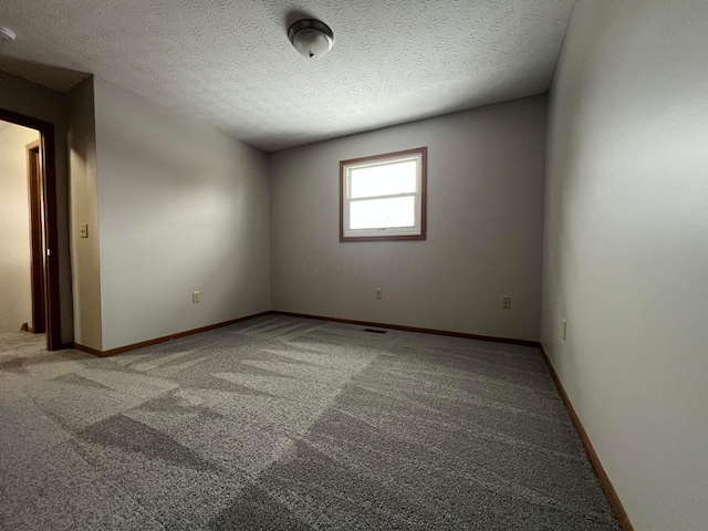 carpeted spare room with a textured ceiling