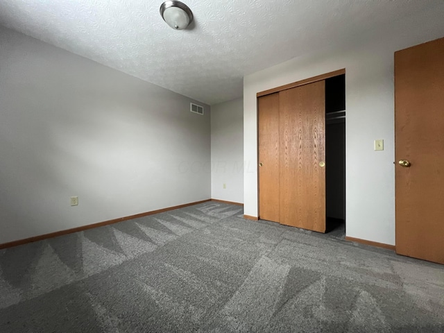 unfurnished bedroom featuring a closet, a textured ceiling, and carpet