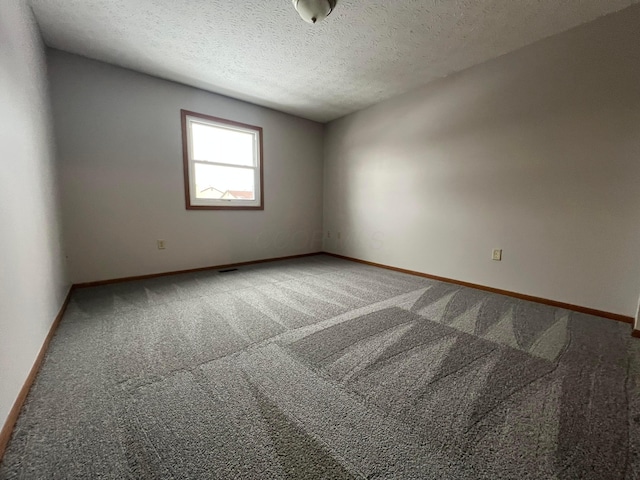 carpeted empty room with a textured ceiling