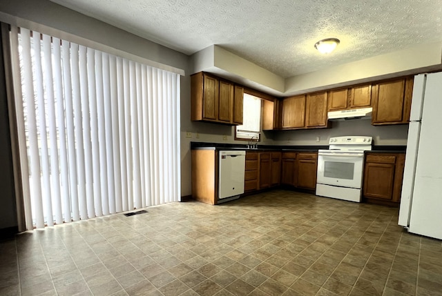 kitchen with white appliances and a textured ceiling