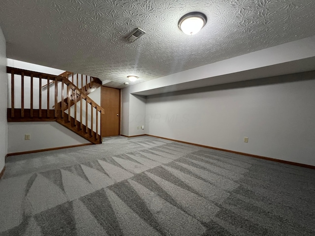 basement with a textured ceiling and carpet flooring