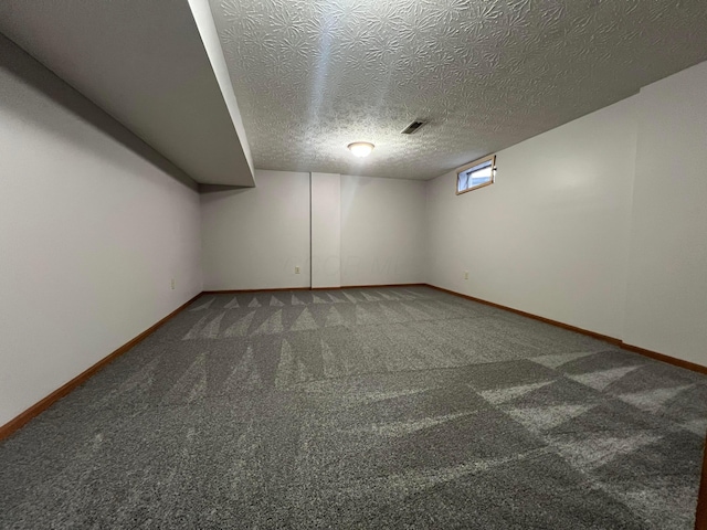 basement with dark carpet and a textured ceiling