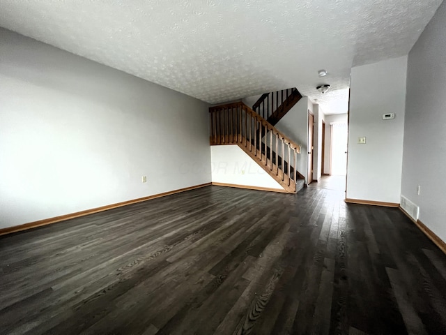 unfurnished living room with dark hardwood / wood-style floors and a textured ceiling