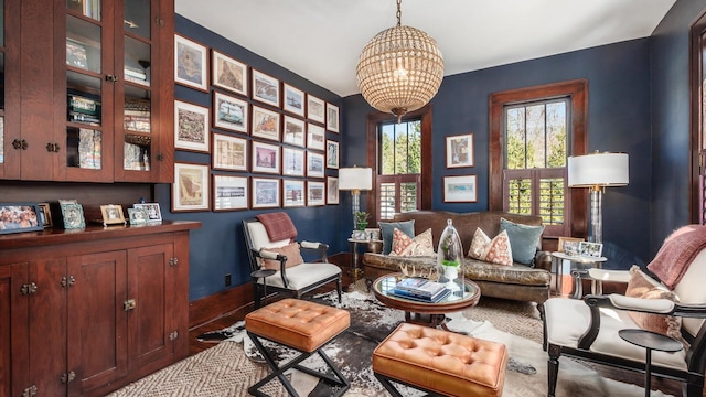 living area with baseboards and a chandelier