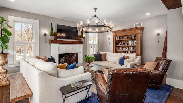 living area with visible vents, dark wood-style floors, recessed lighting, a fireplace, and a chandelier