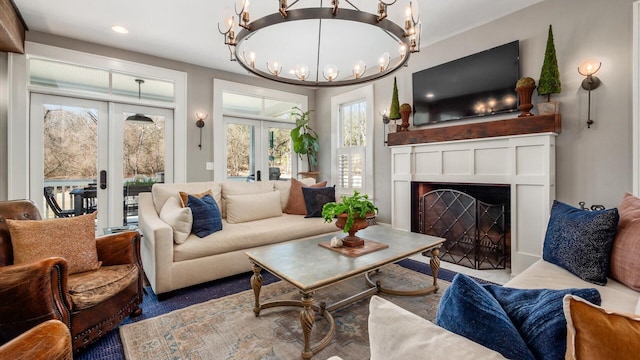 living room featuring a notable chandelier, french doors, and a fireplace with flush hearth