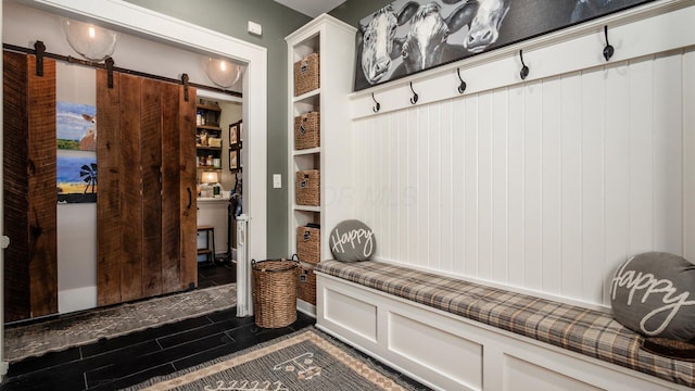 mudroom with a barn door and dark wood-style floors