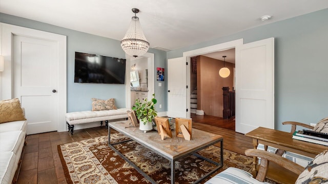 living room featuring stairway, a chandelier, and dark wood-style flooring