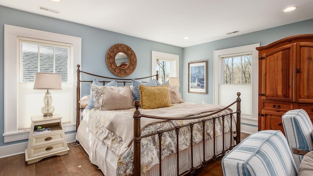 bedroom with dark wood-style floors, visible vents, and recessed lighting