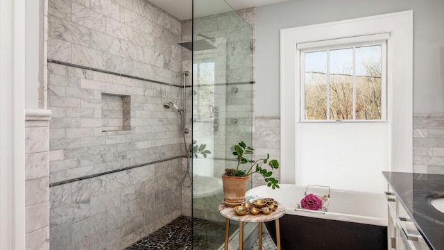 bathroom with a soaking tub, vanity, and a walk in shower