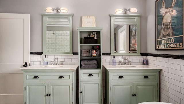 full bathroom featuring a sink, tile walls, and two vanities