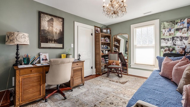 office area with visible vents, baseboards, a notable chandelier, and light wood-style flooring