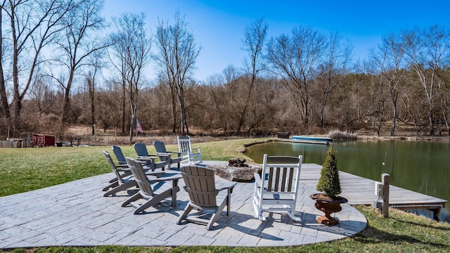 view of patio / terrace featuring a forest view, a water view, a fire pit, and a dock