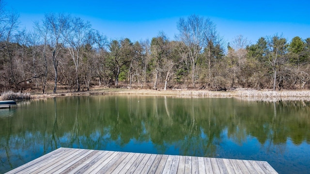 view of dock featuring a forest view and a water view