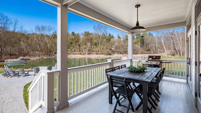 wooden deck with outdoor dining area and area for grilling