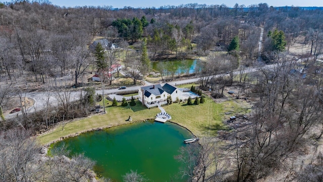 birds eye view of property featuring a forest view and a water view