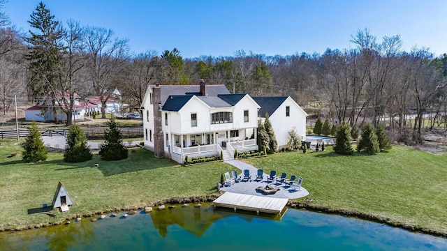 back of property featuring a yard, fence, and a chimney