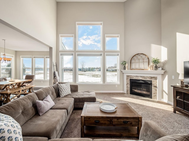 living room featuring a fireplace, a towering ceiling, and carpet floors