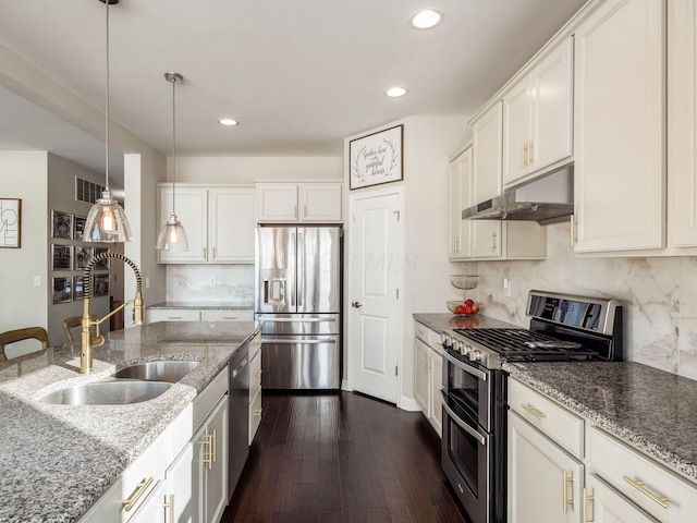 kitchen featuring sink, appliances with stainless steel finishes, white cabinetry, hanging light fixtures, and light stone counters