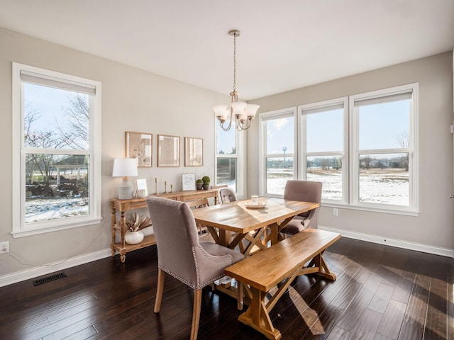 dining room with dark hardwood / wood-style floors and a notable chandelier