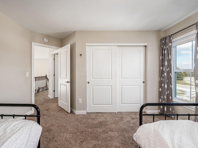 carpeted bedroom featuring a closet and multiple windows