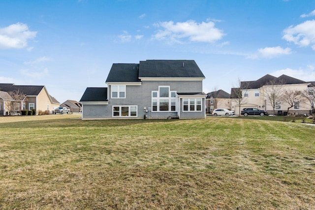 rear view of house featuring a lawn