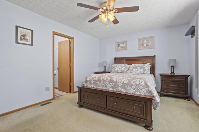 bedroom featuring light colored carpet, a textured ceiling, and ceiling fan