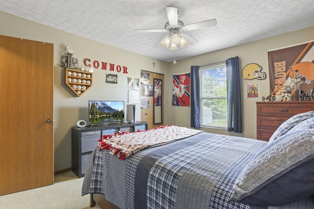 carpeted bedroom featuring a textured ceiling and ceiling fan