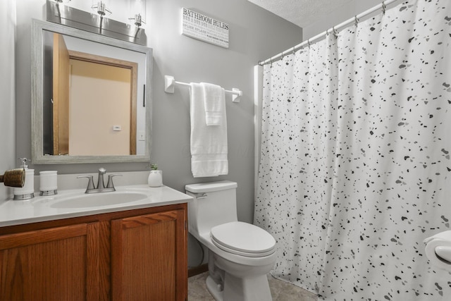 bathroom with tile patterned floors, toilet, a textured ceiling, vanity, and curtained shower