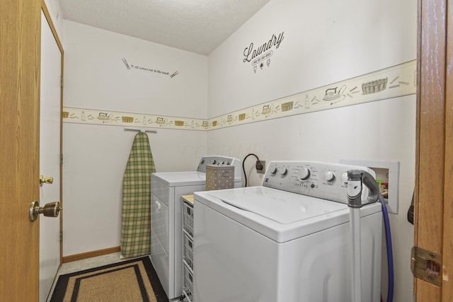 laundry room featuring washer and dryer and a textured ceiling