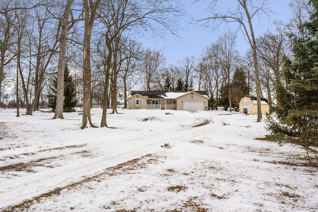 yard layered in snow with a storage unit and an attached garage