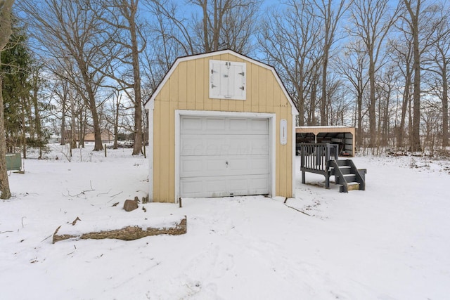 snow covered garage featuring a detached garage