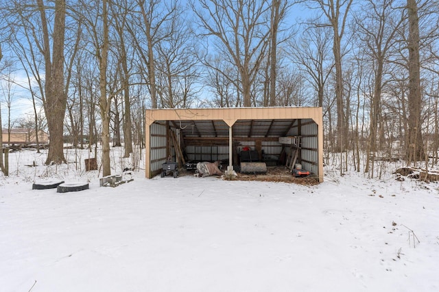 snow covered structure featuring an outbuilding