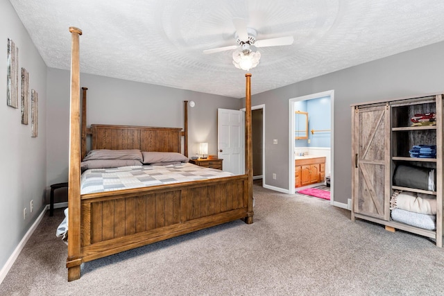 carpeted bedroom with a ceiling fan, baseboards, a textured ceiling, and ensuite bathroom