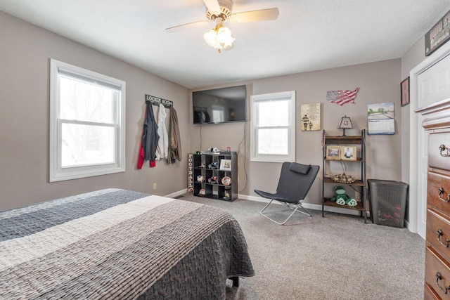 bedroom featuring a ceiling fan, light carpet, and baseboards