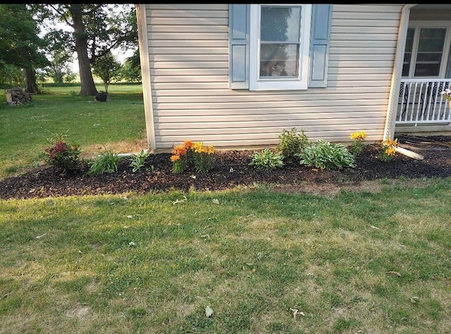 view of side of home with a yard