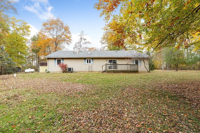 rear view of house featuring a lawn, a deck, and central AC unit