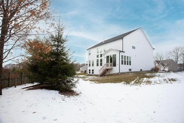 view of snow covered back of property