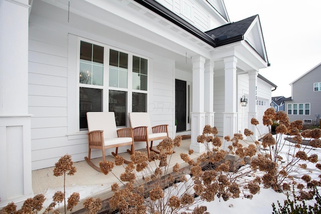 snow covered property entrance with covered porch