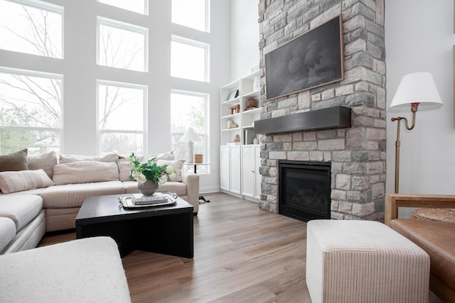 living room with a fireplace, light hardwood / wood-style flooring, and a wealth of natural light